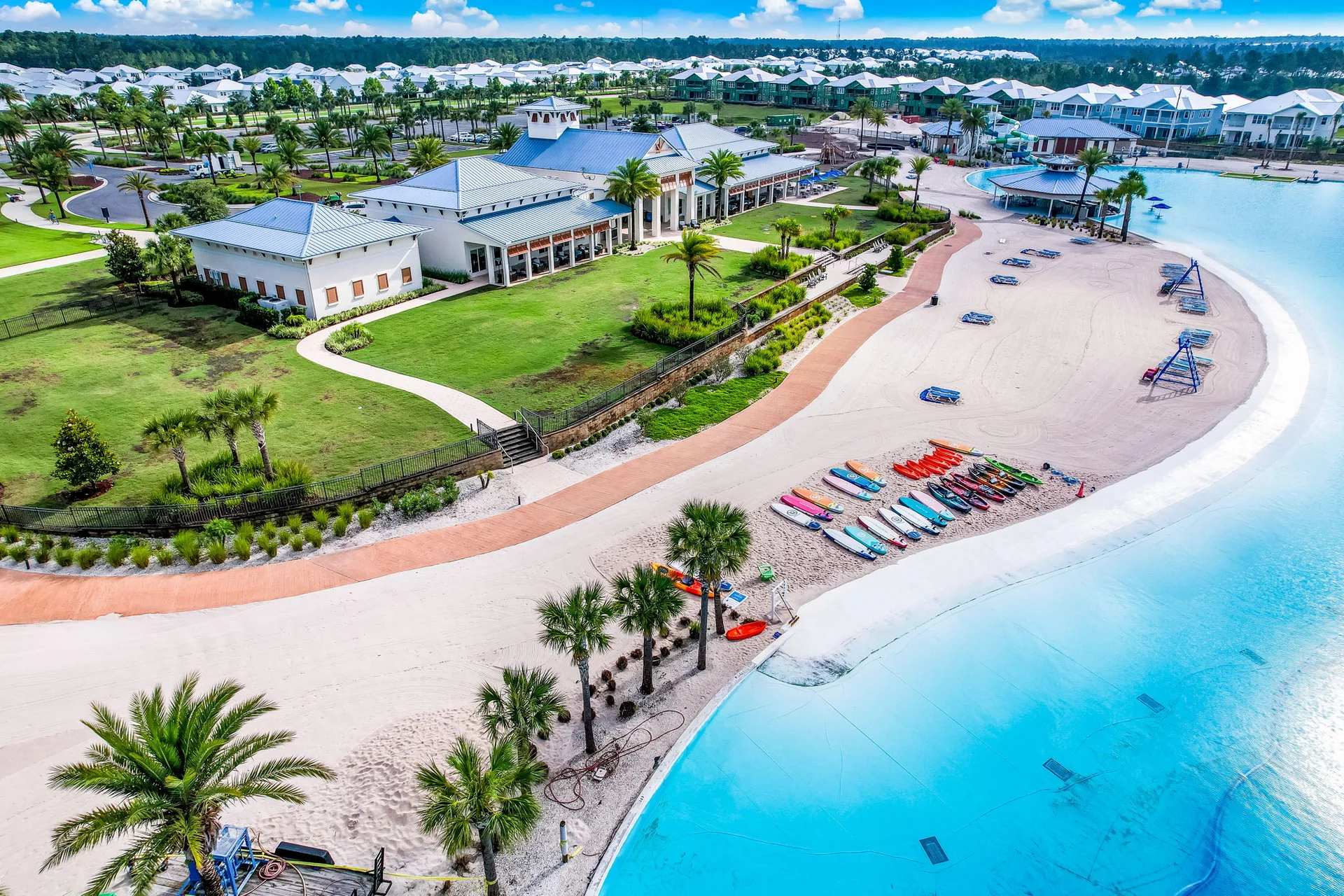 Aerial view of Beachwalk Club, its sandy beach, lagoon, and paddleboards
