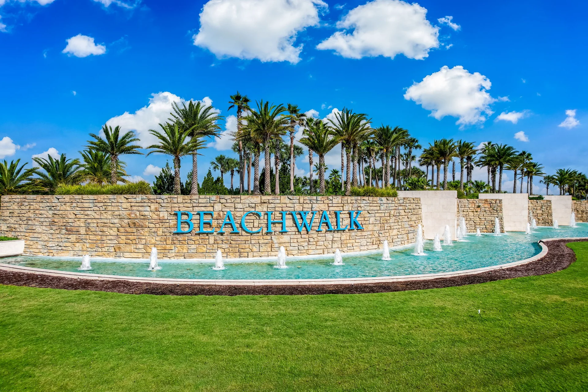 Beachwalk neighborhood monument and fountains beneath palm trees